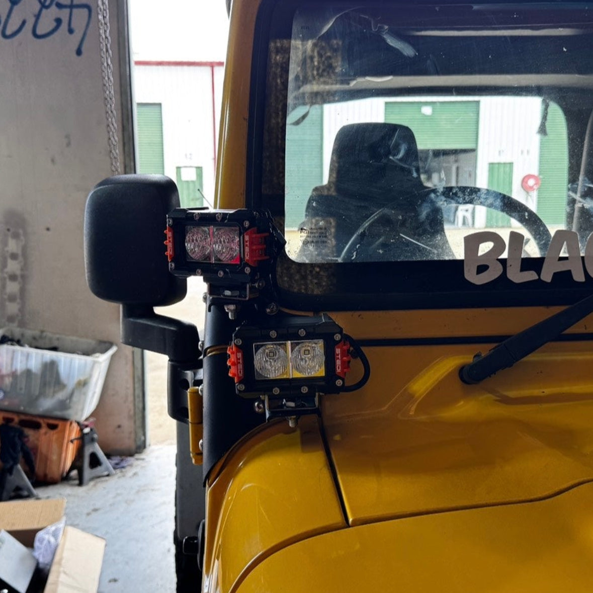 Jeep TJ Wrangler ditch light brackets installed with dual LED lights showing A-pillar mounting and real-world positioning