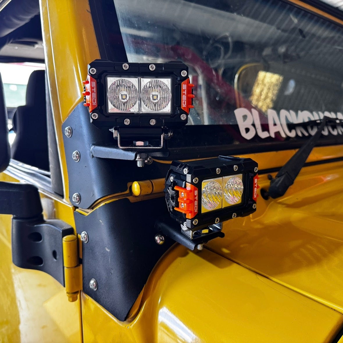 Jeep TJ Wrangler A-pillar ditch light brackets mounted with LED lights showing bonnet clearance and positioning